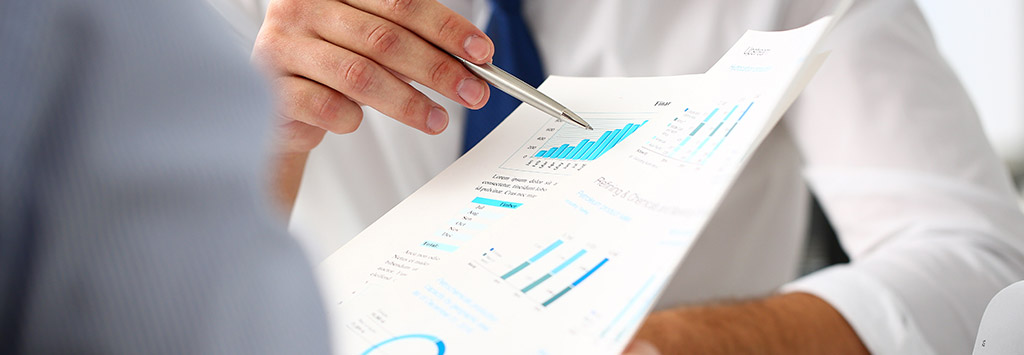Group of businessmen with financial graph and pen